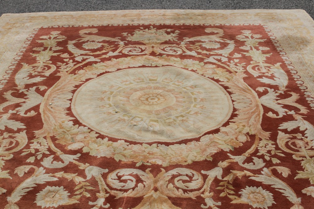 A Chinese terracotta ground carpet, 370 x 276cm